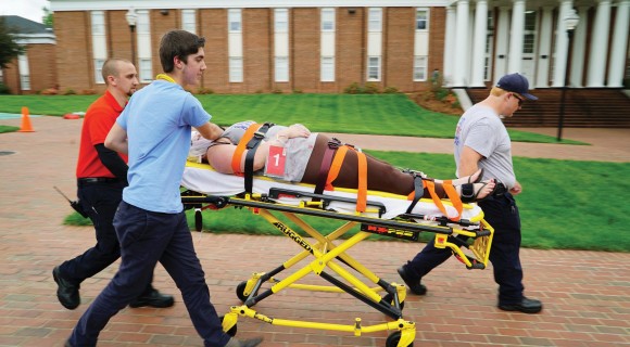 Person being transported on a gurney for an EMT simulation on Mitchell's Statesville Campus.