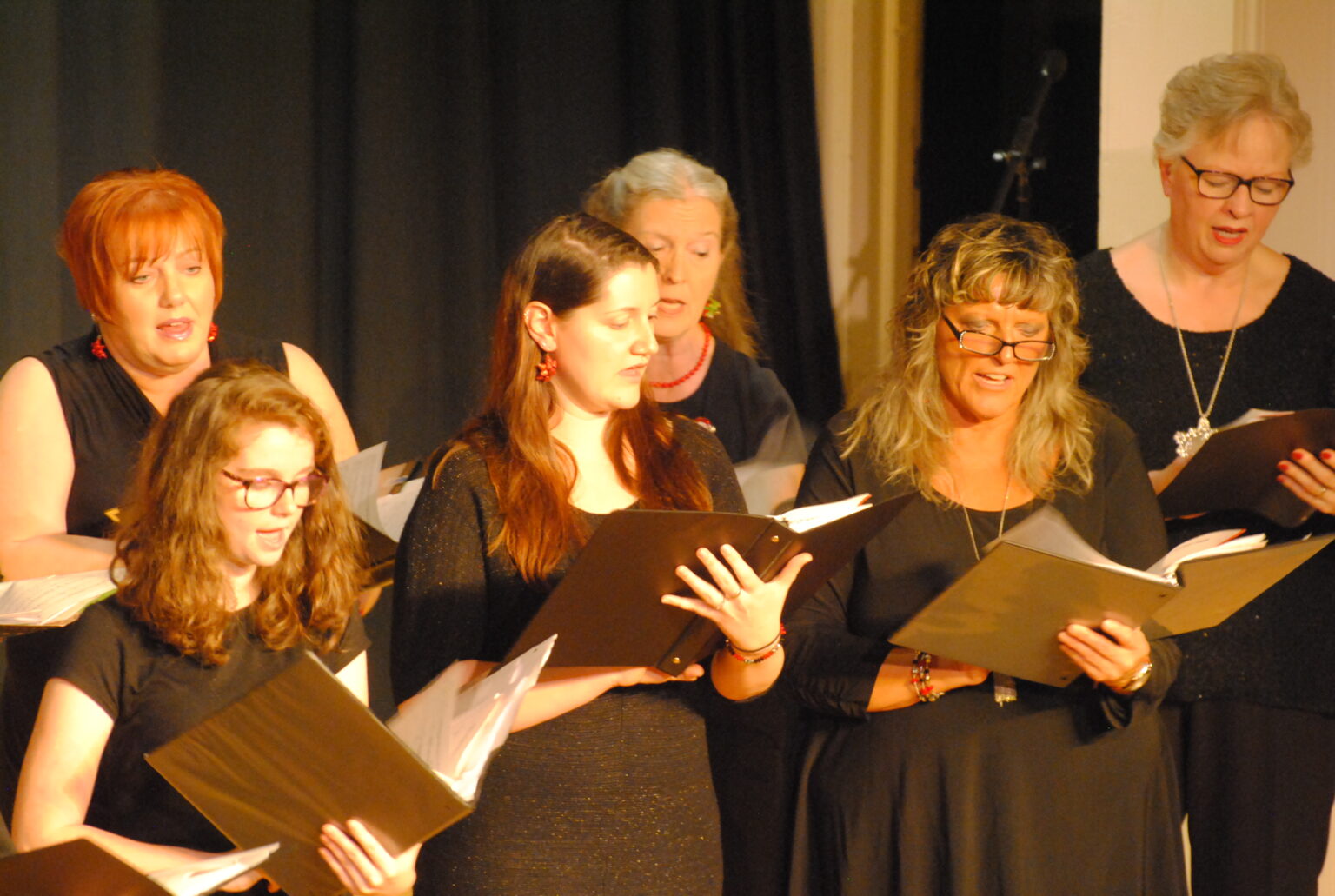 Group of choral singers performing on stage.