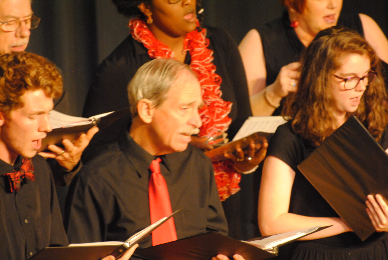 Close-up of a person singing in a choral group.